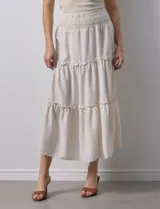 Falda midi a rayas verticales celestes y blancas, con pretina ancha elastizada en punto smock y volados en los cortes.