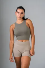 Top corto deportivo color verde oliva, de tejido acanalado, con cuello redondo y sisas anchas.