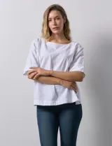 Blusa blanca de algodón marca Erika, de manga corta amplia con tajo en el ruedo lateral y botones.