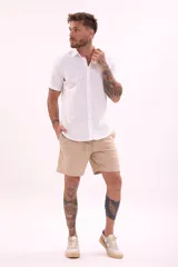 Camisa blanca de manga corta con cuello clásico y cierre frontal con botones.