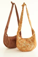 Cartera tipo hobo de gamuza color marrón con etiqueta de cuero con el logo de la marca Foglia.