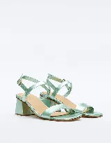 Sandalia de cuero vacuno color verde agua metalizado, con dos tiras en el empeine y tobillo con hebilla ajustable. Taco cuadrado de 4 cm.