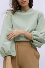 Buzo color verde claro de algodón y elastano, con mangas abullonadas y puños elastizados.