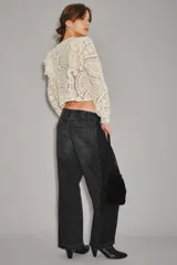 Jean de corte barrel con diseño de pierna curva y holgada, confeccionado en denim negro con efecto lavado. Presenta un estilo moderno y estructurado con costuras laterales marcadas.