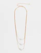 Collar corto de triple cadena dorada con perlas blancas de diferentes tamaños.