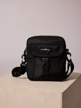 Bandolera gris de nylon con correa negra ajustable y logo Rusty estampado en negro.