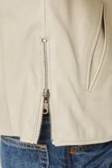 Campera de cuero color natural, con cuello redondo, cierre frontal con cremallera y bolsillos laterales con cierre. Diseño clásico y corte entallado.