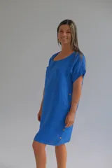 Vestido azul de lino, corte suelto, con escote redondo, mangas cortas y botones decorativos en los laterales.
