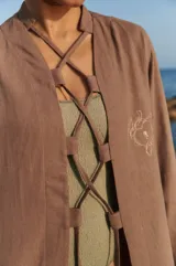 Túnica larga color chocolate confeccionada en lino y rayón, con bordado a tono en el delantero y lazos ajustables. Presenta tajos laterales.