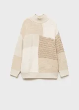Sweater de punto grueso color beige con diseño patchwork. Tiene cuello alto y mangas largas.