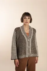 Cárdigan tejido a rayas verticales marrones y beige, con cuello esmoquin, cierre frontal con botones y corte holgado. Tejido en 100% lana fina sin teñir.