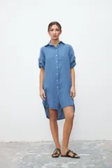 Vestido camisero celeste de lino con cuello clásico, abotonadura frontal y mangas 3/4 con trabillas.