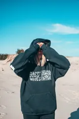Buzo hoodie negro con estampa en la espalda y mangas con letras blancas.