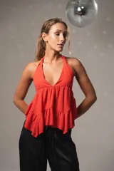 Top color rosa de gasa con escote halter, volados en el ruedo y espalda descubierta con tiras para atar.