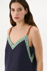 Musculosa azul con breteles finos color marrón y escote en V.