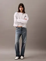 Remera blanca de algodón con cuello redondo y logo CK bordado en el pecho. Corte cropped y mangas cortas.