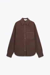 Camisa marrón de manga larga con cuello solapa, bolsillo de parche en el pecho y cierre frontal con botones.