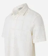 Camisa de manga corta color crema con textura cuadriculada con lesie, cuello inglés y abotonado delantero.