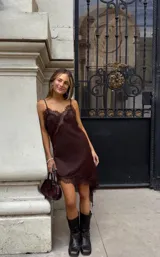 Vestido corto marrón con breteles finos y detalles de encaje en escote y ruedo.