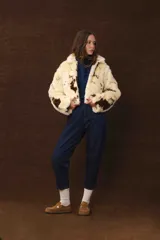 Chaqueta corta de piel sintética color crema con manchas marrones.