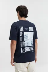 Remera lila de manga corta con cuello redondo y estampado pequeño en el pecho.