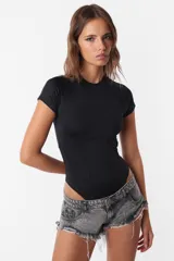 Body negro de microfibra con mangas cortas y cuello redondo. Tiene recortes con costuras a la vista y espalda descubierta. Se abrocha en la entrepierna con broches snap y tiene elástico interno en el contorno de tiro.