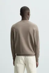 Jersey color topo de corte amplio, tejido en hilatura con mezcla de viscosa. Tiene cuello redondo, manga larga y terminaciones en rib.