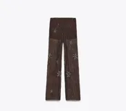 Pantalón de tul marrón con bordados de estrellas plateadas.