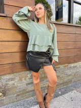 Blusa color ladrillo con corte a la cintura y volados. Mangas largas acampanadas.