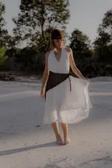 Vestido largo de color blanco, con escote en V pronunciado y tiras largas que permiten anudarlo de múltiples formas. Presenta tajo en ambos laterales y forro interno.