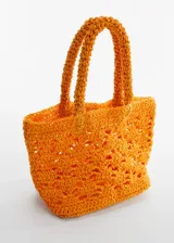 Bolso pequeño de rafia color naranja con diseño de tejido y asas cortas.