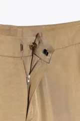 Pantalón palazzo color beige de tiro alto, con bolsillos delanteros y pernera ancha.