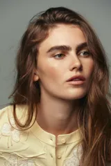 Cárdigan amarillo pálido de punto con cuello redondo, manga larga y cierre frontal con botones. Decorado con apliques florales de abalorios.