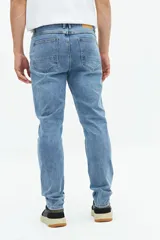 Jean slim azul oscuro, tiro medio, con pasacintos y confeccionado en 98% algodón y 2% spandex.