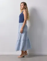 Falda midi a rayas verticales celestes y blancas, con pretina ancha elastizada en punto smock y volados en los cortes.