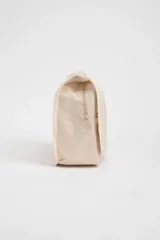 Neceser de viaje color beige con cierre de cremallera y asa de mano. Tiene un pequeño logo rectangular en el frente.