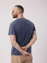 Remera azul con cuello redondo y tapeta con botones. Tiene un acabado desgastado.