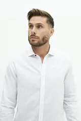 Camisa de lino color beige, de manga larga, corte semi slim y logo bordado en el pecho.