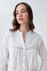 Camisa blanca de manga larga con bordados en el frente y cuello.