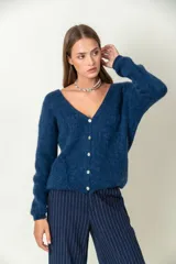 Cárdigan azul de mohair con escote en V, cierre frontal con botones y mangas largas.