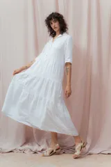 Vestido midi blanco de lino, con cuello camisero, mangas 3/4 y corte evasé.