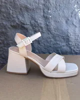 Sandalia de cuero vacuno en tono dorado, con taco de 8 cm y tiras ajustables.