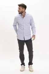 Camisa celeste a rayas verticales, de corte clásico, con cuello abotonado y mangas largas.