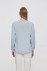 Sweater tejido de punto color celeste con cuello redondo y mangas largas.