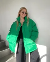 Campera puffer verde, de corte oversize, con cuello alto y cierre frontal con botones a presión y cremallera.