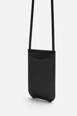 Bolso bandolera negro de cuero con bolsillo plano frontal y correa fina al hombro.