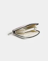 Billetera de cuerina color blanco con estampado de flores en tonos lila, naranja y amarillo. Tiene cierre superior, compartimentos para tarjetas y billetes, y un bolsillo interno con cierre.