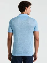 Polo celeste con textura jaspeada, cuello clásico, manga corta y logo bordado en el pecho.