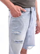 Bermuda de jean celeste con roturas y terminación desflecada.