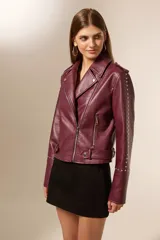 Chaqueta tipo biker color borgoña de cuero sintético con tachas plateadas en hombros y mangas, cierre asimétrico y cuello solapa.